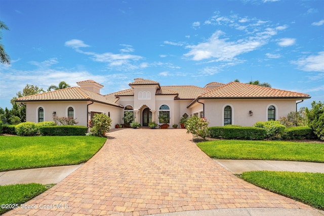 7346 Gorda Peak Ct, Melbourne, FL 32940 - mediterranean / spanish-style home featuring a garage, decorative driveway, stucco siding, and a front yard