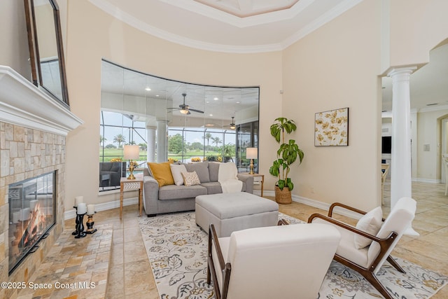 7346 Gorda Peak Ct, Melbourne, FL 32940 - living room featuring ornamental molding, a towering ceiling, ornate columns, a glass covered fireplace, and ceiling fan