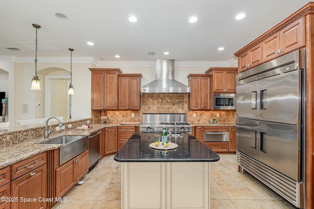 7346 Gorda Peak Ct, Melbourne, FL 32940 - kitchen with built in appliances, wall chimney range hood, a sink, a warming drawer, and brown cabinetry