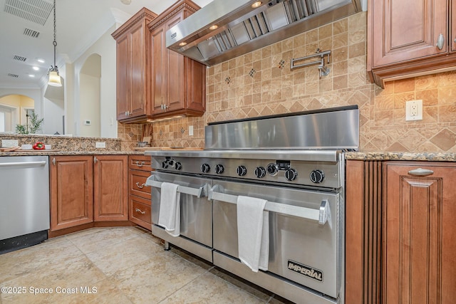 7346 Gorda Peak Ct, Melbourne, FL 32940 - kitchen featuring appliances with stainless steel finishes, brown cabinets, crown molding, arched walkways, and custom range hood