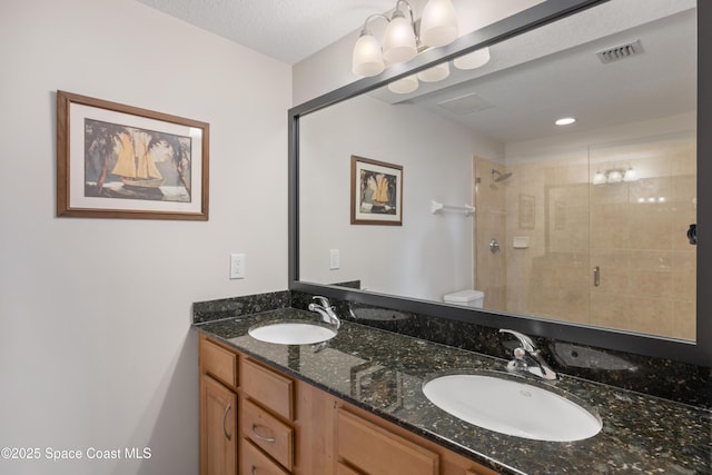 bathroom with a stall shower, visible vents, toilet, and a sink