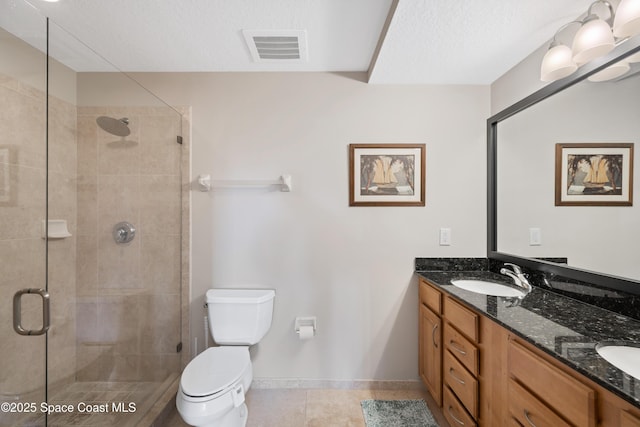 bathroom featuring double vanity, toilet, a stall shower, a sink, and visible vents