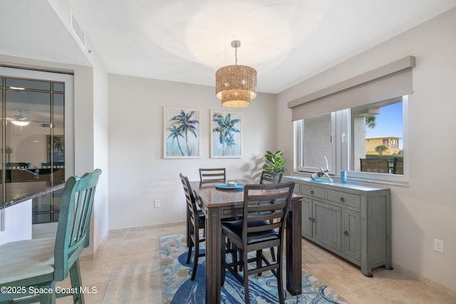 dining area featuring light tile patterned floors, baseboards, an inviting chandelier, and visible vents