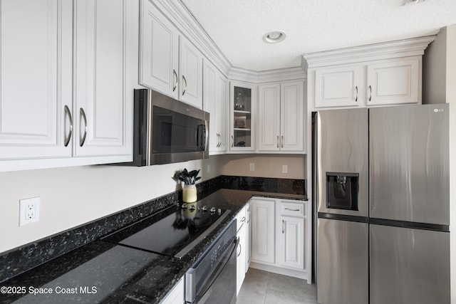 kitchen with light tile patterned flooring, white cabinetry, glass insert cabinets, and appliances with stainless steel finishes