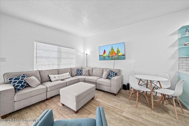 215 Jefferson Ave, Cape Canaveral, FL 32920 - living room with a textured ceiling and light wood finished floors