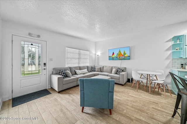 215 Jefferson Ave, Cape Canaveral, FL 32920 - living room with light wood finished floors and a textured ceiling