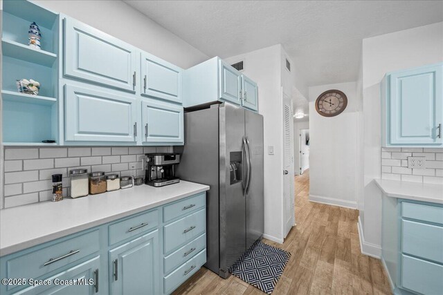 215 Jefferson Ave, Cape Canaveral, FL 32920 - kitchen with stainless steel fridge with ice dispenser, decorative backsplash, light wood-type flooring, and light countertops