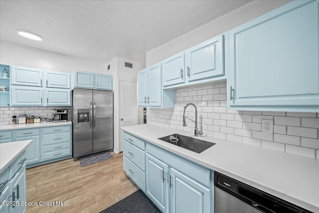 215 Jefferson Ave, Cape Canaveral, FL 32920 - kitchen featuring stainless steel appliances, a sink, tasteful backsplash, light countertops, and a textured ceiling