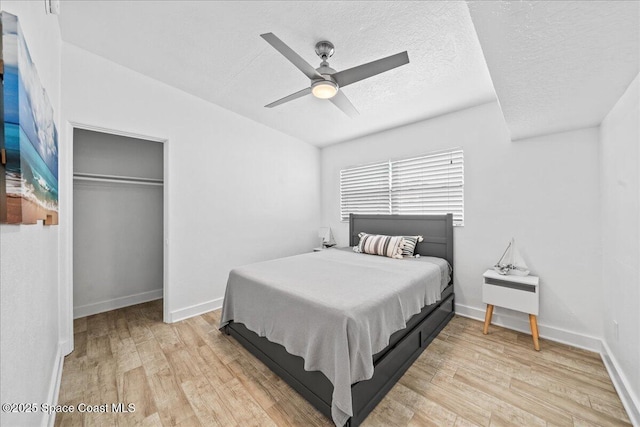 215 Jefferson Ave, Cape Canaveral, FL 32920 - bedroom with light wood finished floors, a textured ceiling, a closet, baseboards, and a ceiling fan