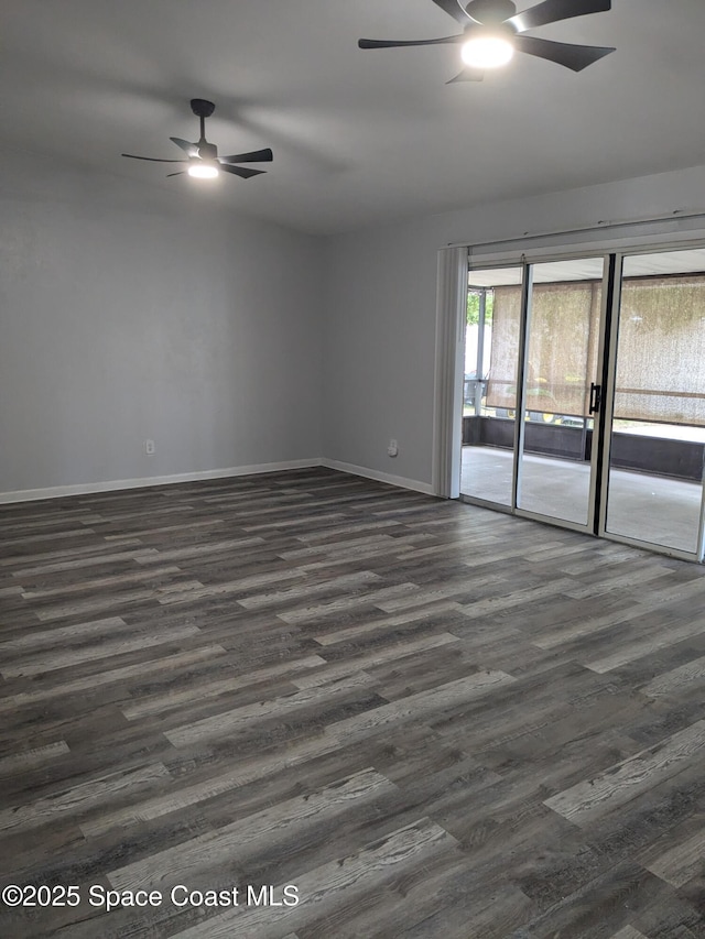 spare room featuring a ceiling fan, dark wood finished floors, and baseboards