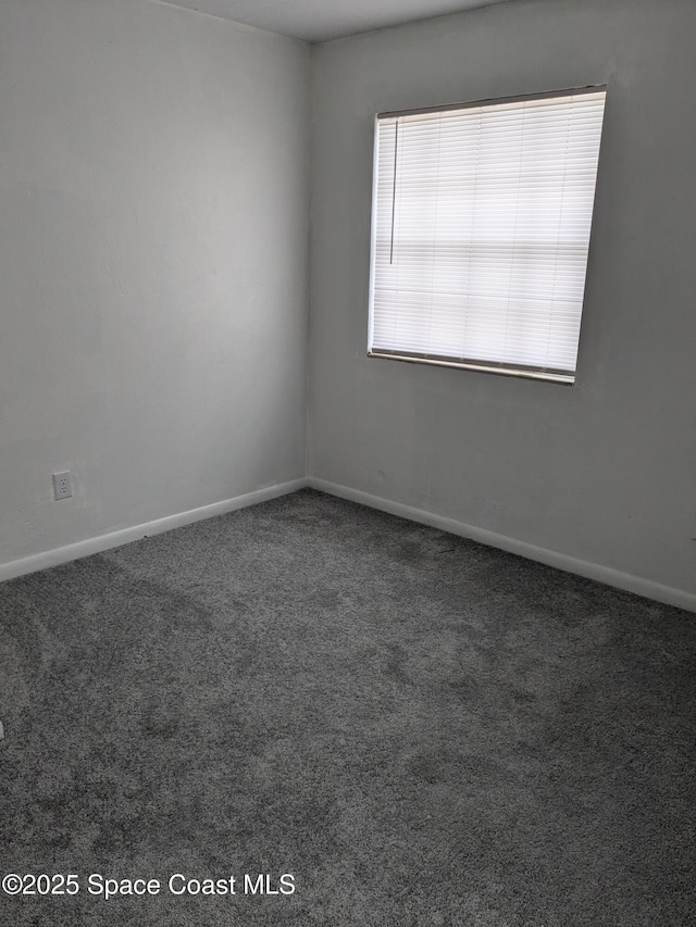 spare room featuring carpet flooring and baseboards