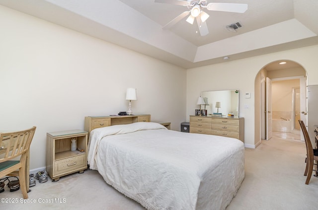 730 Sunset Lakes Dr, Merritt Island, FL 32953 - bedroom with light colored carpet, arched walkways, baseboards, a tray ceiling, and ceiling fan