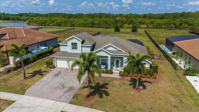 view of front of property featuring decorative driveway, a garage, a porch, a water view, and stucco siding