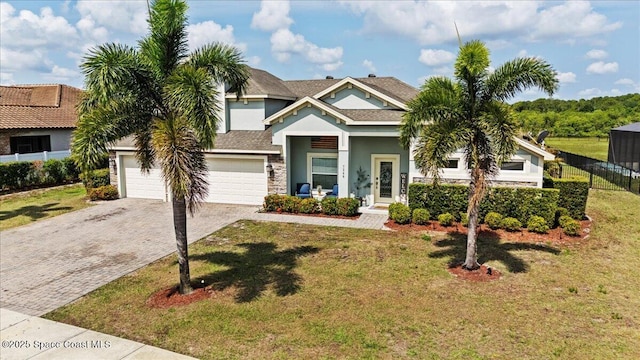 view of front of house with decorative driveway, stucco siding, stone siding, and an attached garage