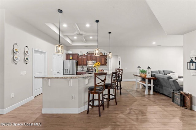 7268 Preserve Pointe Dr, Merritt Island, FL 32953 - kitchen with stainless steel appliances, recessed lighting, a breakfast bar area, light wood-style flooring, and coffered ceiling