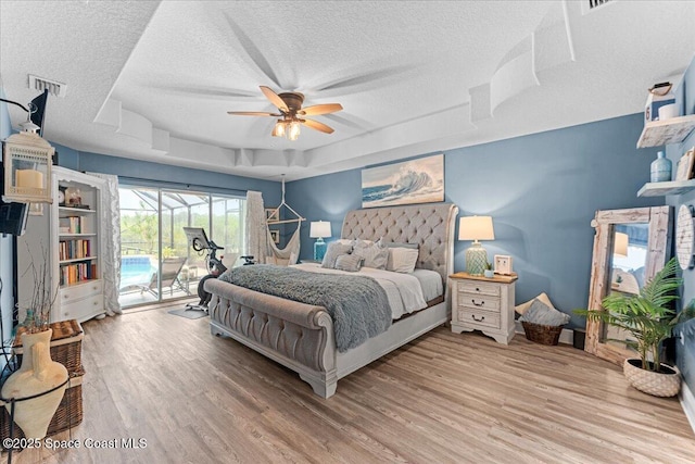 7268 Preserve Pointe Dr, Merritt Island, FL 32953 - bedroom featuring access to exterior, a textured ceiling, a raised ceiling, wood finished floors, and a ceiling fan
