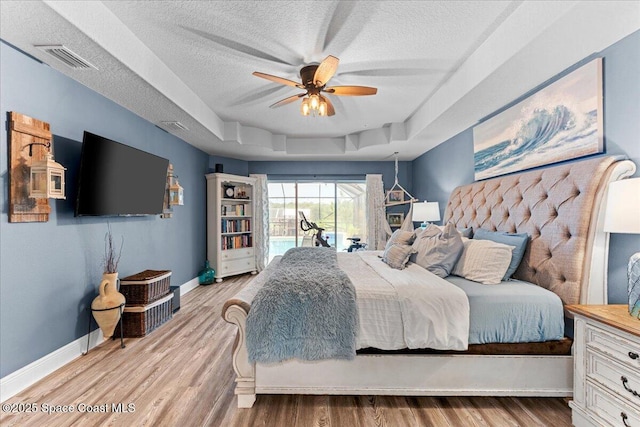7268 Preserve Pointe Dr, Merritt Island, FL 32953 - bedroom featuring access to outside, a textured ceiling, a raised ceiling, baseboards, and wood finished floors