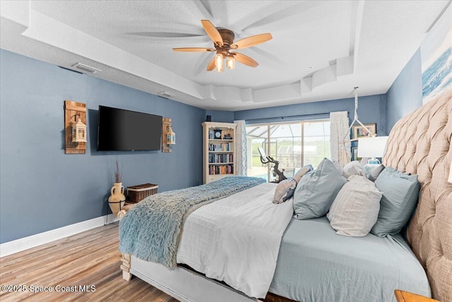 7268 Preserve Pointe Dr, Merritt Island, FL 32953 - bedroom with a raised ceiling, baseboards, wood finished floors, and a ceiling fan