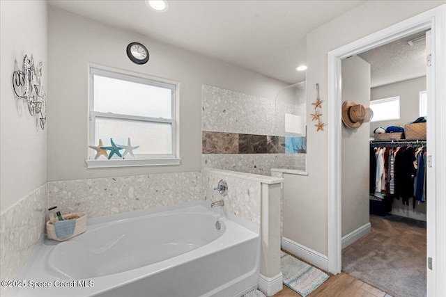 7268 Preserve Pointe Dr, Merritt Island, FL 32953 - full bathroom with a bath, wood finished floors, a walk in closet, a walk in shower, and recessed lighting