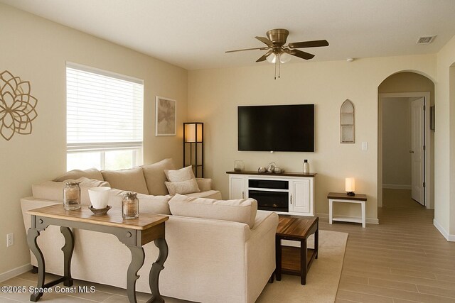 735 Sorrento Dr, Cocoa, FL 32922 - living room featuring ceiling fan, arched walkways, light wood-style floors, and baseboards