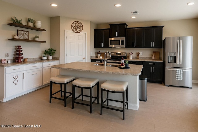 735 Sorrento Dr, Cocoa, FL 32922 - kitchen featuring stainless steel appliances, a sink, open shelves, a breakfast bar area, and recessed lighting
