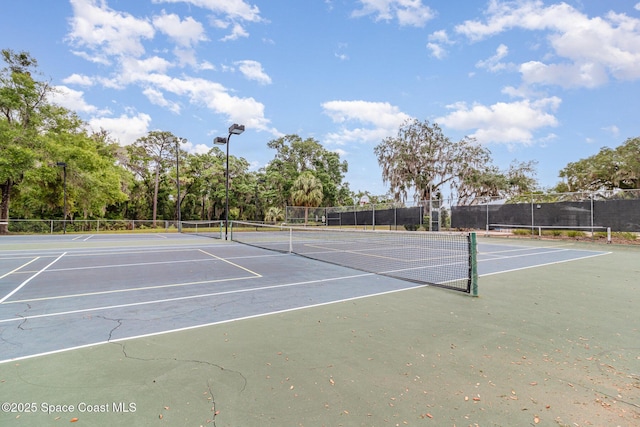 view of tennis court featuring fence and community basketball court