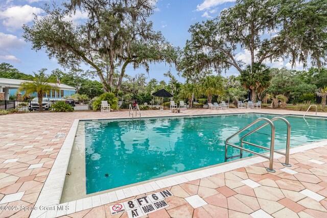 community pool featuring fence and a patio area