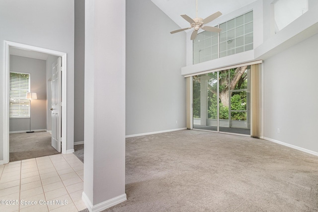 unfurnished living room featuring carpet flooring, high vaulted ceiling, ceiling fan, and baseboards
