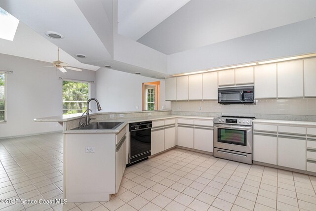 kitchen featuring black appliances, a sink, a peninsula, light tile patterned floors, and backsplash