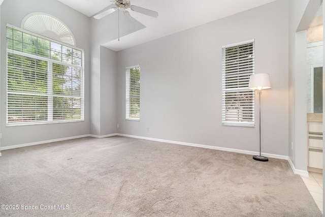 unfurnished room featuring carpet floors, ceiling fan, plenty of natural light, and baseboards