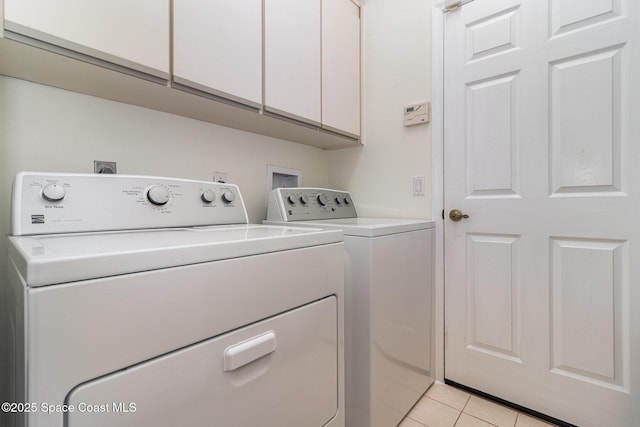 laundry area with separate washer and dryer, cabinet space, and light tile patterned floors