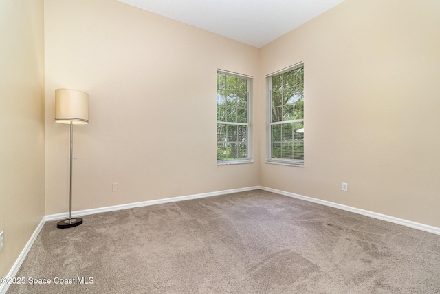 empty room featuring carpet floors and baseboards