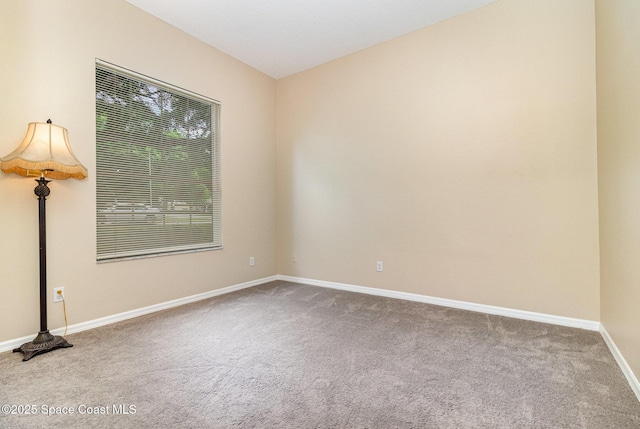 spare room featuring carpet floors and baseboards