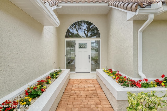 entrance to property with stucco siding and a tiled roof
