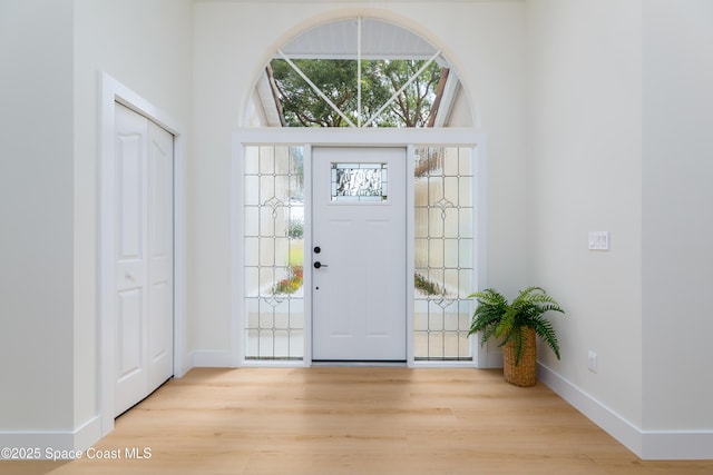 foyer entrance with wood finished floors and baseboards