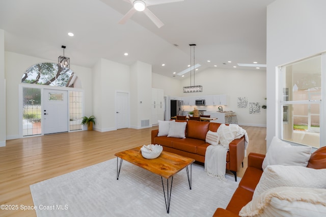 living area featuring high vaulted ceiling, light wood-style flooring, recessed lighting, baseboards, and ceiling fan