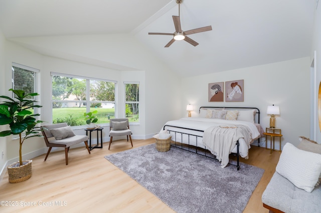 bedroom with wood finished floors, beamed ceiling, a ceiling fan, and high vaulted ceiling