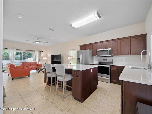 354 Dryden Cir, Cocoa, FL 32926 - kitchen with appliances with stainless steel finishes, a sink, a kitchen island, light countertops, and open floor plan