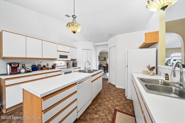 kitchen with white appliances, arched walkways, a sink, vaulted ceiling, and white cabinets