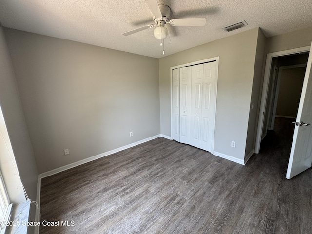 539 Olsmar St SW, Palm Bay, FL 32908 - unfurnished bedroom featuring dark wood finished floors, a closet, a textured ceiling, baseboards, and ceiling fan