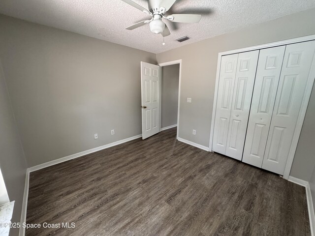 539 Olsmar St SW, Palm Bay, FL 32908 - unfurnished bedroom with dark wood-type flooring, a textured ceiling, a closet, baseboards, and ceiling fan