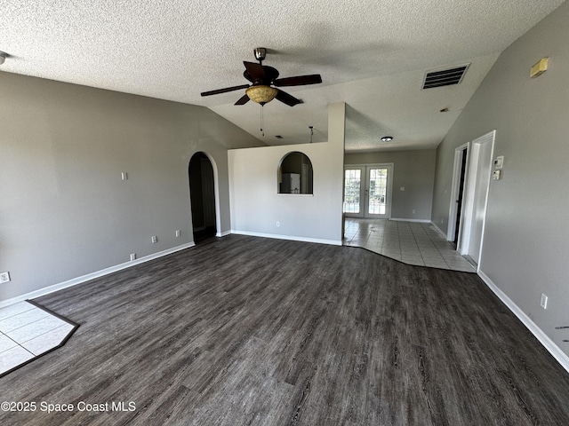 539 Olsmar St SW, Palm Bay, FL 32908 - unfurnished living room with lofted ceiling, ceiling fan, dark wood-type flooring, arched walkways, and a textured ceiling