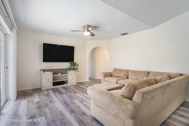 4920 48th Pl, Vero Beach, FL 32967 - living room with arched walkways, wood finished floors, a ceiling fan, and baseboards