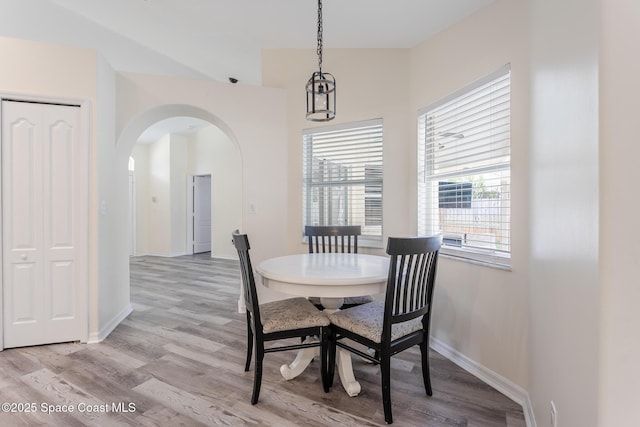 4920 48th Pl, Vero Beach, FL 32967 - dining space with arched walkways, light wood finished floors, and baseboards