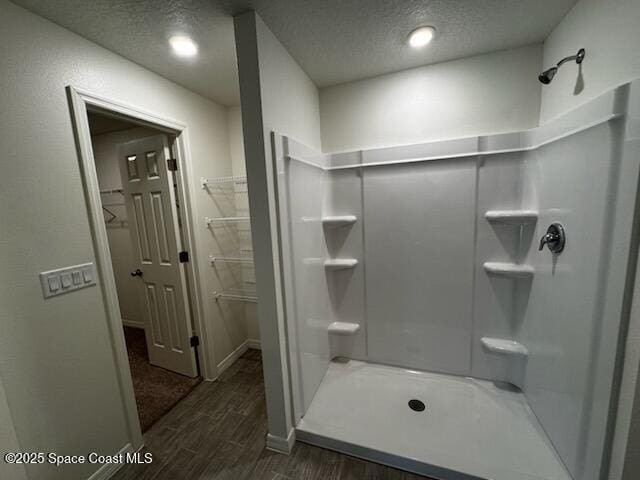 2683 Palomar Ave SE, Palm Bay, FL 32909 - full bath with a shower stall, wood finished floors, a walk in closet, baseboards, and a textured ceiling