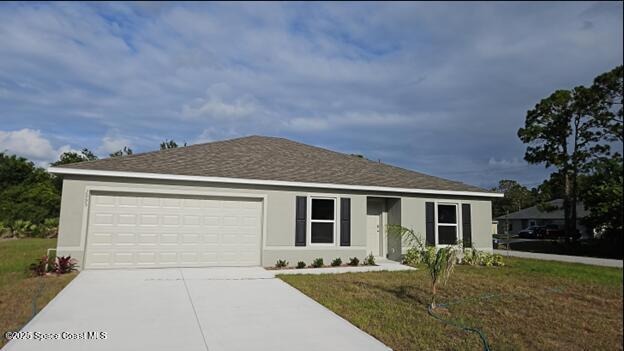 ranch-style home with concrete driveway, a garage, stucco siding, and a front yard