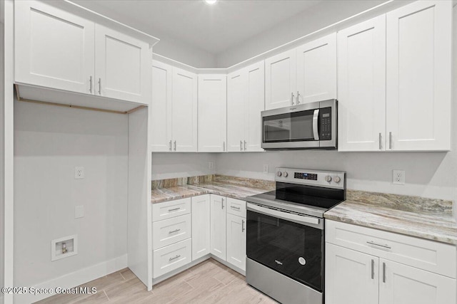 998 Wacona St SE, Palm Bay, FL 32909 - kitchen featuring stainless steel appliances, light wood finished floors, and white cabinets