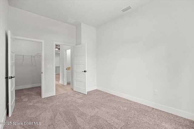 998 Wacona St SE, Palm Bay, FL 32909 - unfurnished bedroom featuring carpet flooring, baseboards, a spacious closet, and a closet