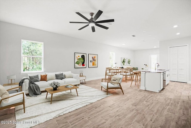 998 Wacona St SE, Palm Bay, FL 32909 - living area featuring light wood finished floors, a ceiling fan, recessed lighting, and baseboards