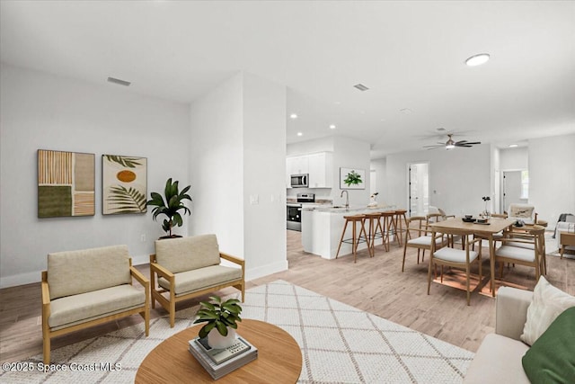 998 Wacona St SE, Palm Bay, FL 32909 - living area featuring light wood finished floors, ceiling fan, baseboards, and recessed lighting
